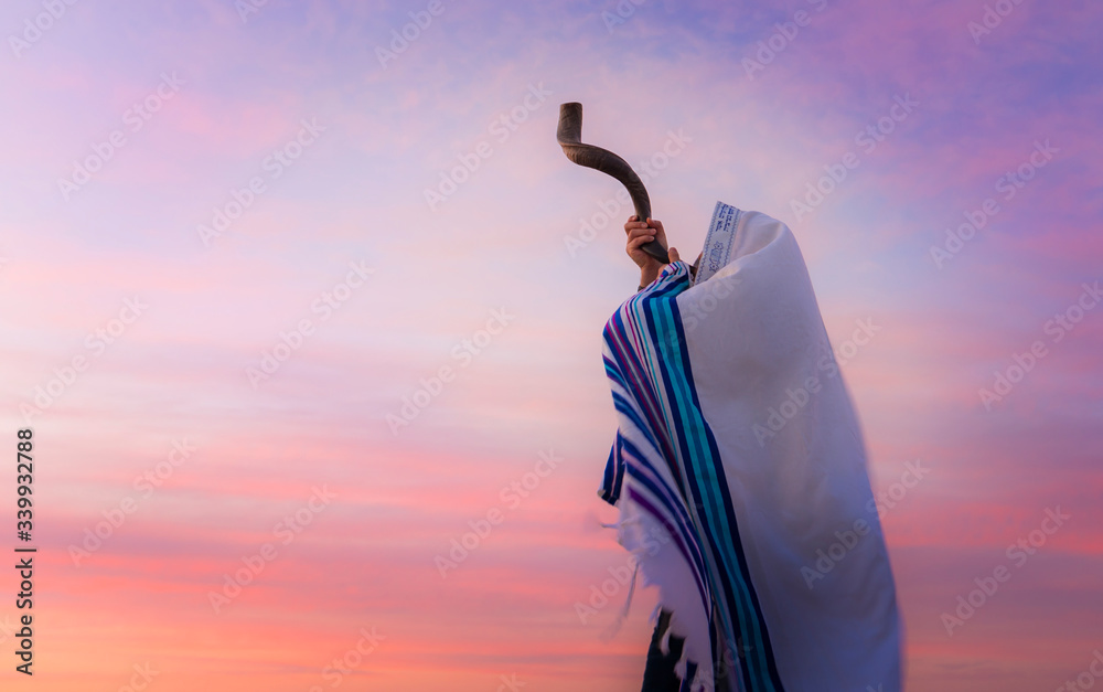 Blowing the Shofar man in a tallith, Jewish prayer shawl is blowing