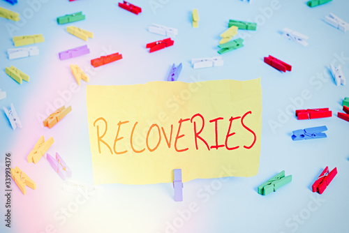 Handwriting text writing Recoveries. Conceptual photo process of regaining possession or control of something lost Colored clothespin papers empty reminder blue floor background office pin photo