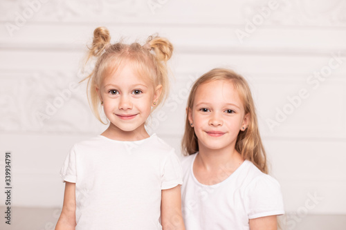 Wallpaper Mural Two little cute sisters pose for a photo standin next to each other. Soft focus Torontodigital.ca