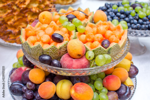 Melon basket. Decorative artistic fruit carving. Wedding catering company table tray. Colorful vitamin background. Various selection of fruits on banquet reception.