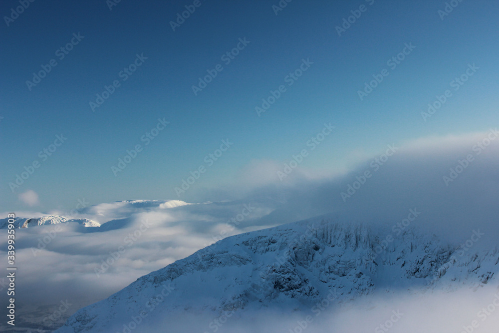 snow capped mountains shrouded in clouds