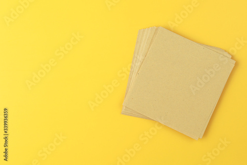 Stack of recycle brown papers on yellow background.