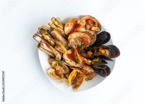 Sauteed shellfish and seafood in a white plate on a white background