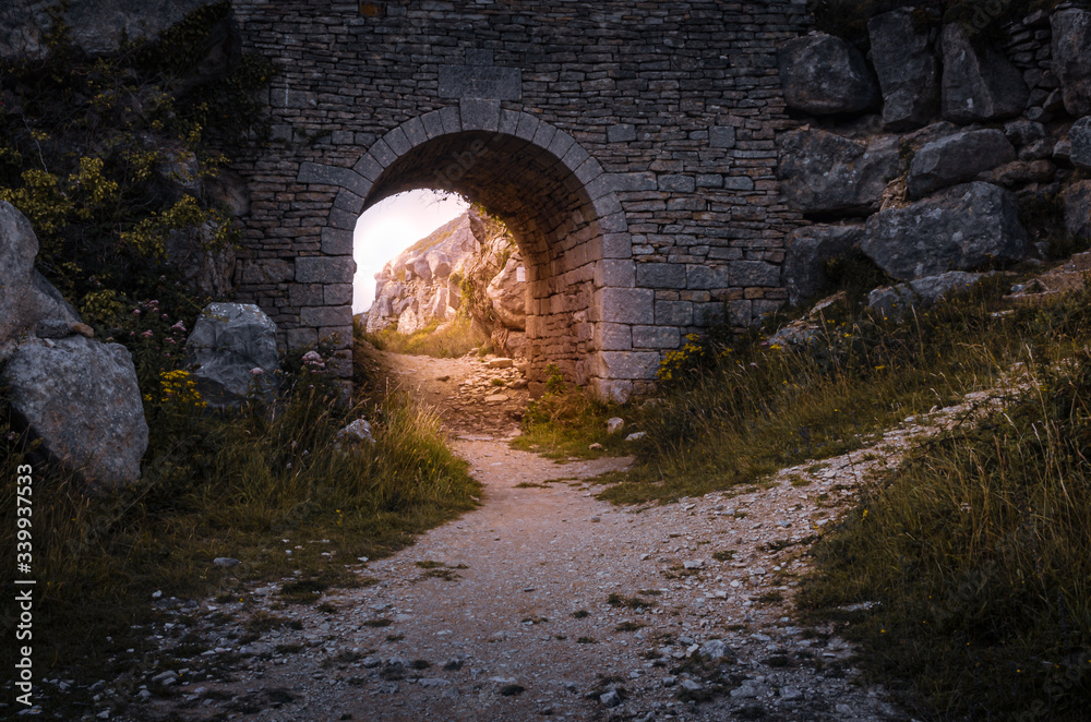 Old quarry bridge with golden sunlight shining through at Tout Quarry, Isle of Portland, Weymouth, Dorset, United Kingdom