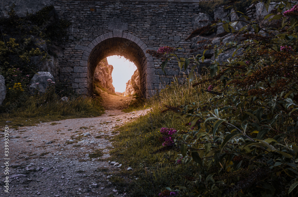 Old quarry bridge with golden sunlight shining through at Tout Quarry, Isle of Portland, Weymouth, Dorset, United Kingdom