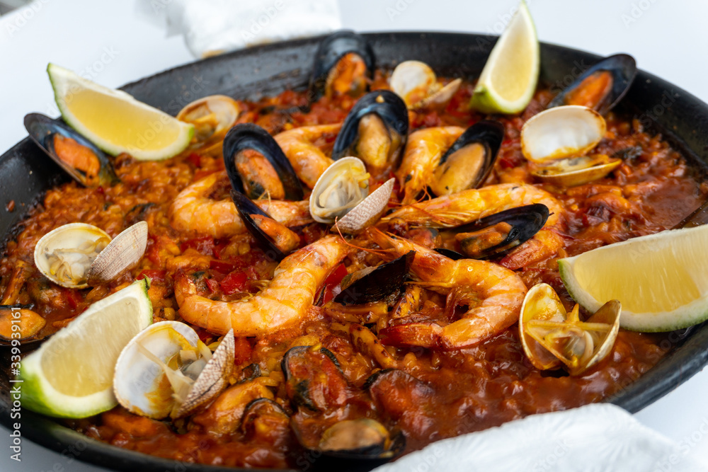 Fototapeta premium Fish and seafood paella on a white background