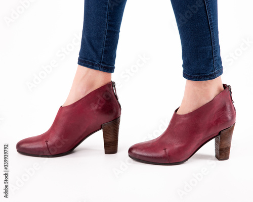Stylish fashionable women's shoes on legs on a white background in studio