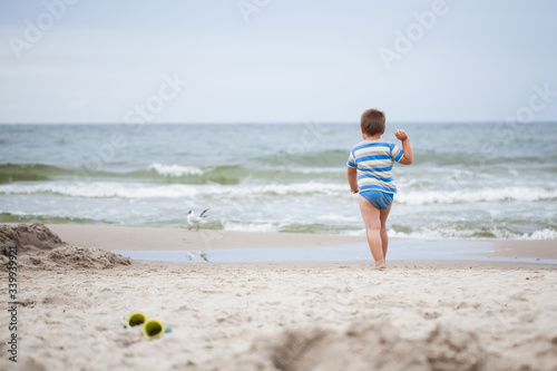Obraz na płótnie child running towards the sea. A child running on the beach w salonie
