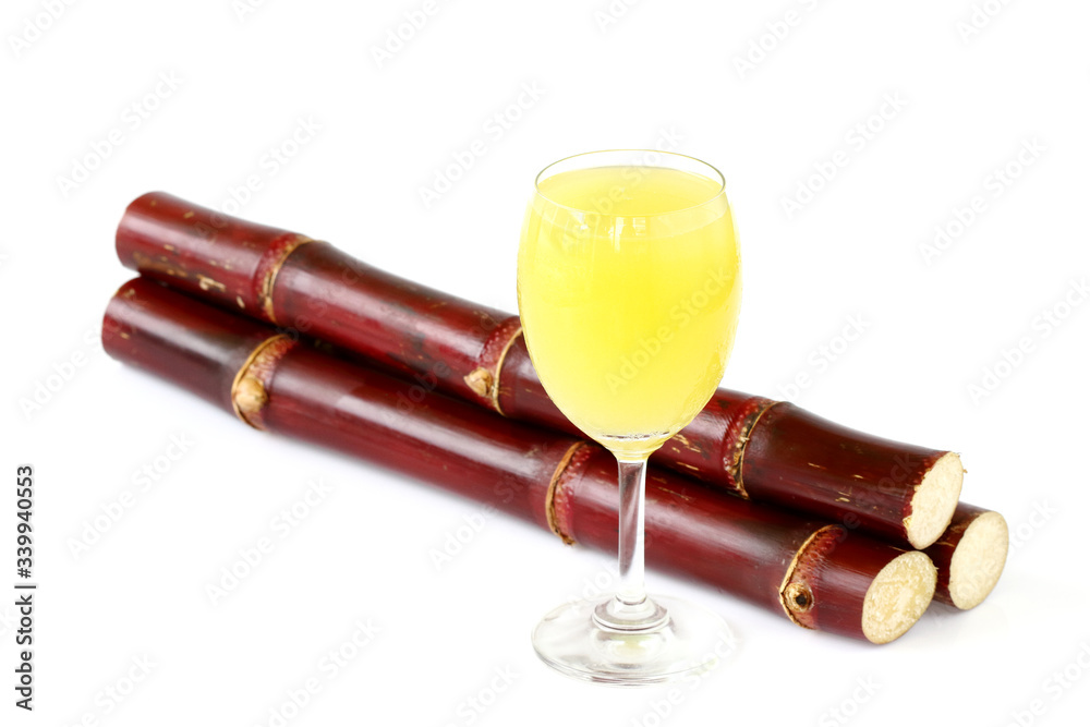 Fresh squeezed sugar cane juice in glass with cut pieces cane isolate on white background. Health Benefits of Sugarcane Juice