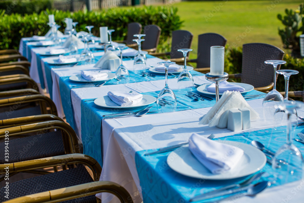 Fototapeta premium Cozy restaurant table setting in blue style with sea view