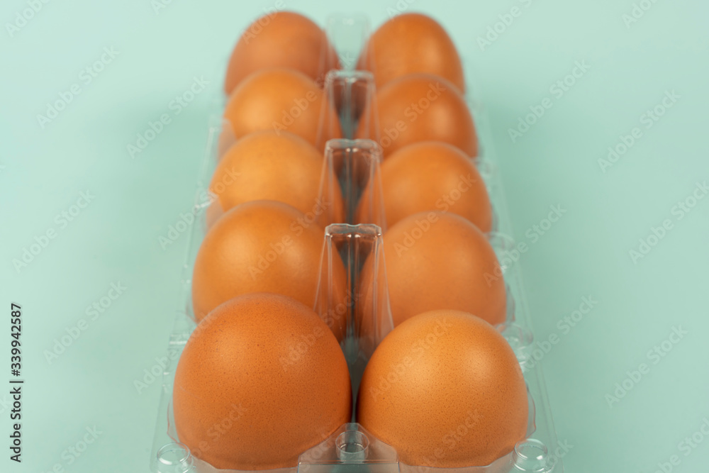 Eggs in a plastic package with isolated turquoise background. Eggs in a plastic package with isolated turquoise background.