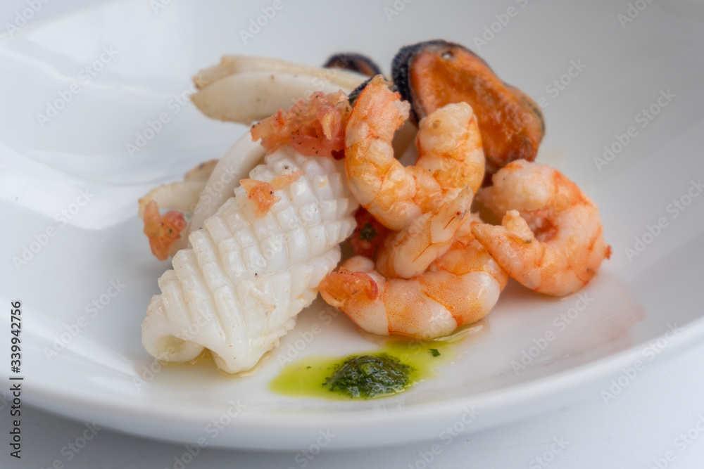 Fancy FISH AND SEAFOOD with soup on a white plate with a white background Fancy FISH AND SEAFOOD with soup on a white plate with a white background