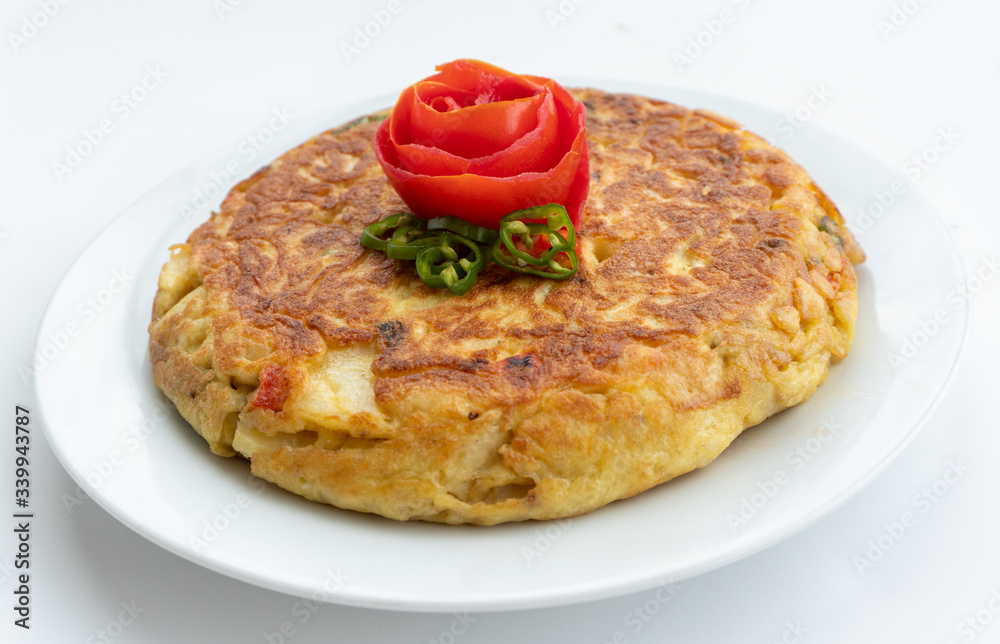 Tortilla espanola, Spanish omelette with potatoes with a tomato flower on top Tortilla espanola, Spanish omelette with potatoes with a tomato flower on top
