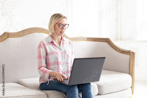 Confident woman sitting on the sofa and and tutoring remotly photo