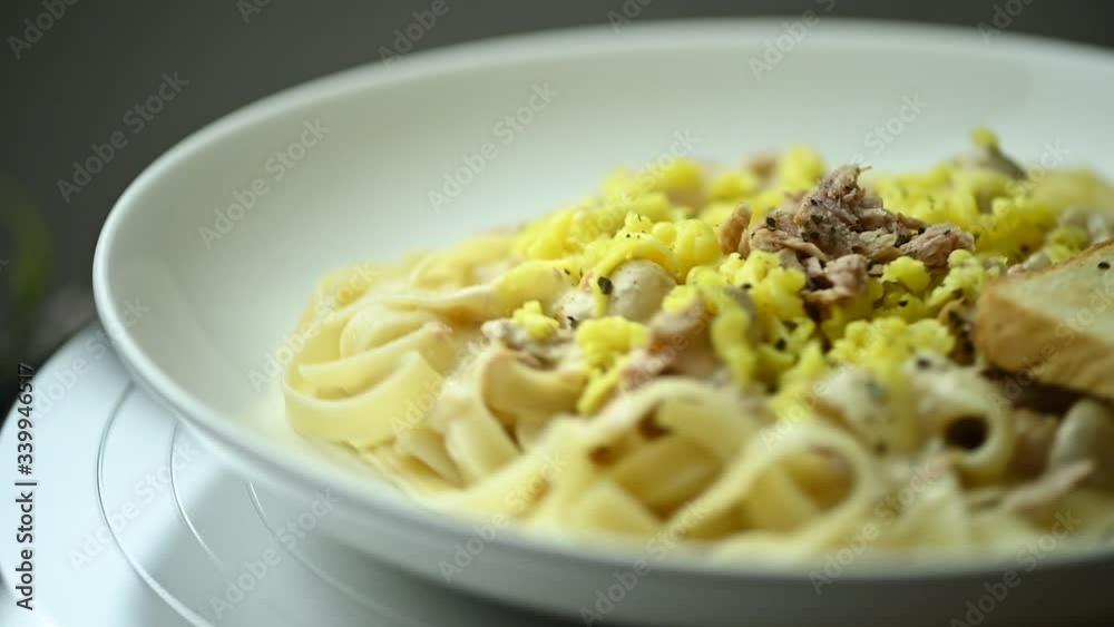 Homemade Creamy Tuna and Mushroom Fettuccine Pasta topped with grated cheddar cheese-slow motion turn Homemade Creamy Tuna and Mushroom Fettuccine Pasta topped with grated cheddar cheese-slow motion turn