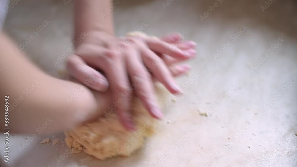 the woman begins to knead the dough on the table for making cookies, top view, close up the woman begins to knead the dough on the table for making cookies, top view, close up