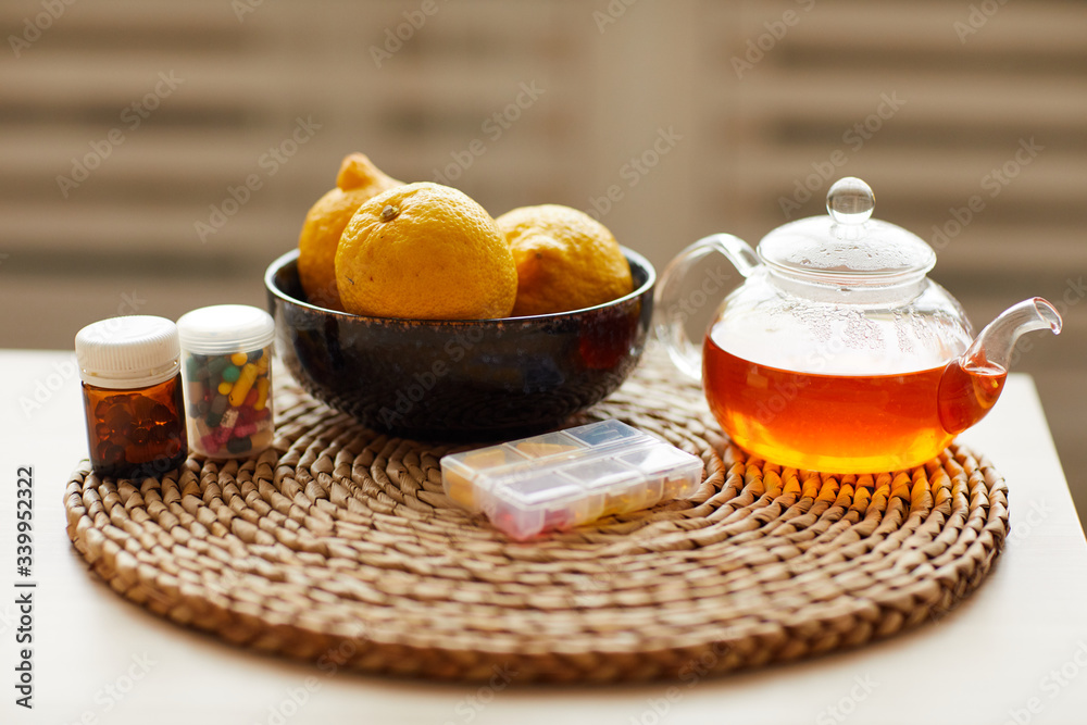 Close-up of table with hot tea lemons and vitamins from epidemic and colds Close-up of table with hot tea lemons and vitamins from epidemic and colds