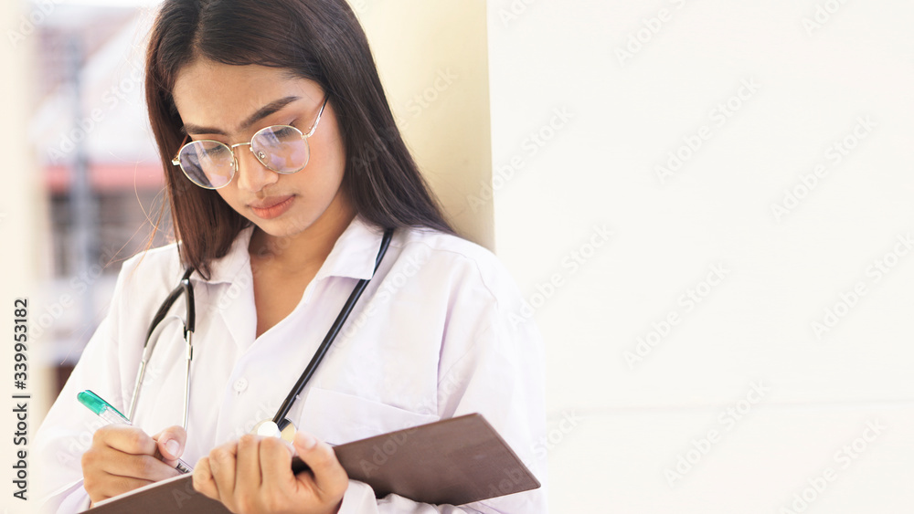 Young Asian woman the doctor doing a record in book concept. Young Asian woman the doctor doing a record in book concept.