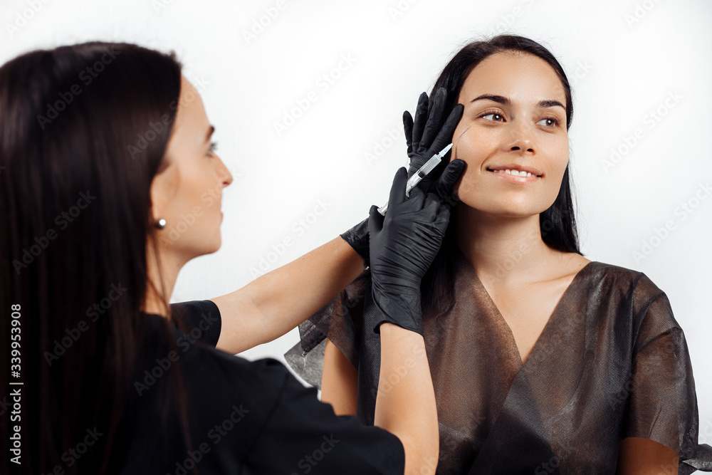 Beautiful young woman gets beauty facial injections in salon. Face aging and hydration procedures. Beautiful young woman gets beauty facial injections in salon. Face aging and hydration procedures.
