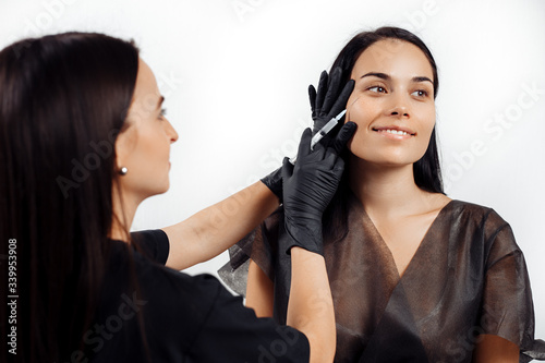 Beautiful young woman gets beauty facial injections in salon. Face aging and hydration procedures.