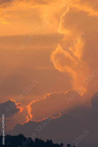 sunset orange and yellow cumulus clouds in a summer day