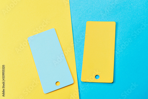 abstract composition of 2 design cards, comparison of two yellow and blue colored cards on a two-color paper background