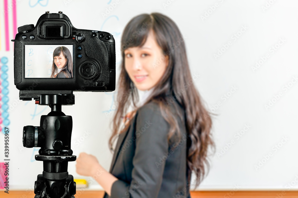 Asian American teacher streaming class with camera