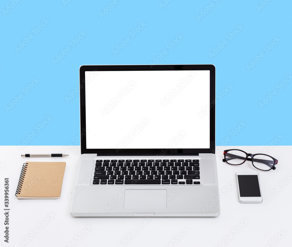 Laptop computer on desk with isolated screen for mockup on blue background. business and technology concept Laptop computer on desk with isolated screen for mockup on blue background. business and technology concept