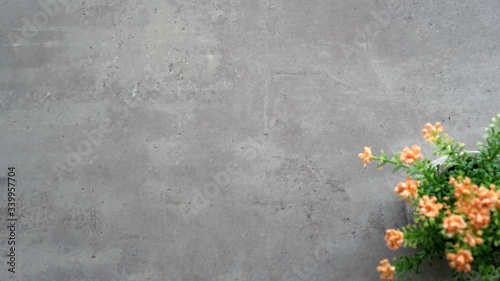 Green and yellow plastic flowers on the table surface with gray cement