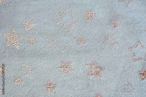 Backdrop made of small golden stars on beige textile