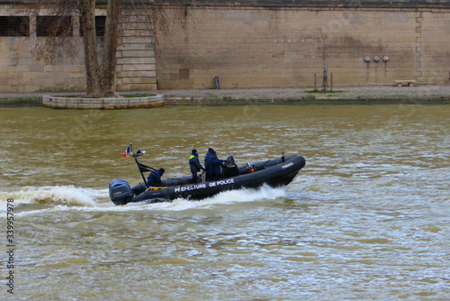 View of the Seine River and a black police boat sailing at high speed. photo