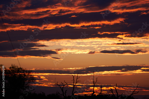 A spectacular Texas Desert Sunset with red sky a bright clouds photo