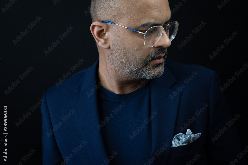 Obraz premium Bearded man in a t shirt and suit jacket with pocket square in retro glasses. 