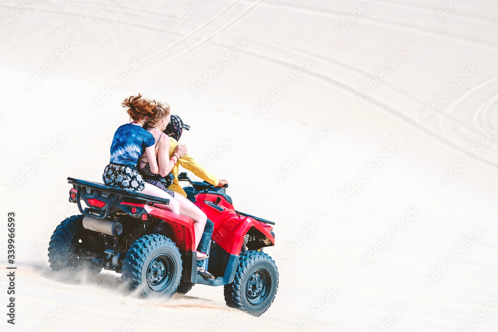 Tourist enjoy riding the quad bike or powerful fast off-road four-wheel drive ATVs at white sand dunes in Mui Ne, Vietnam. Tourist enjoy riding the quad bike or powerful fast off-road four-wheel drive ATVs at white sand dunes in Mui Ne, Vietnam.