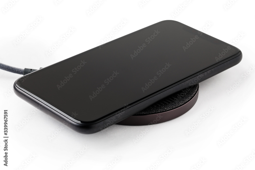 The smartphone is charged by a wireless charger  Concept of new technologies.