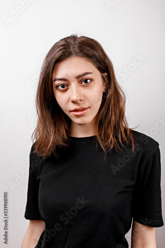 Sad brunette woman looks upset at the camera on a white background. isolated © Yura