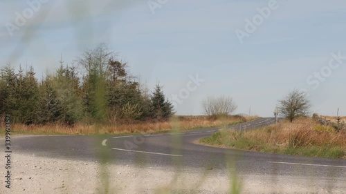 Man Mountain Biking along an empty countryside road before turning off road