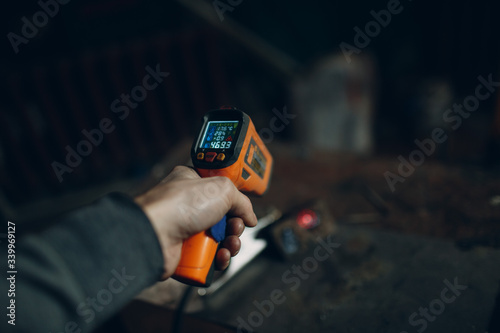 Laser thermometer with display in hand.