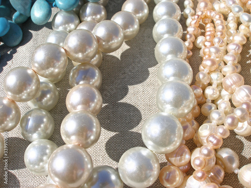  Pearl necklaces on light textured fabric beads shimmer in the light 