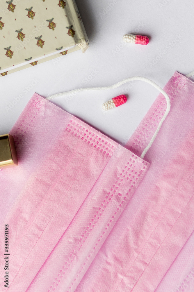 pink female medical mask on the background. women's accessories, women's everyday kit, still life. Means of protection from Kovid-19 pink female medical mask on the background. women's accessories, women's everyday kit, still life. Means of protection from Kovid-19