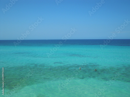 Mar turquesa paradisíaco con dos personas nadando © Cesar Tezza