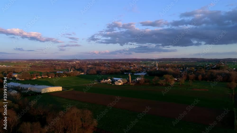 Aerial view of the golden hour looking over Pennsylvania farm lands with barns and blue skies and clouds
Aerial view of the golden hour looking over Pennsylvania farm lands with barns and blue skies and clouds