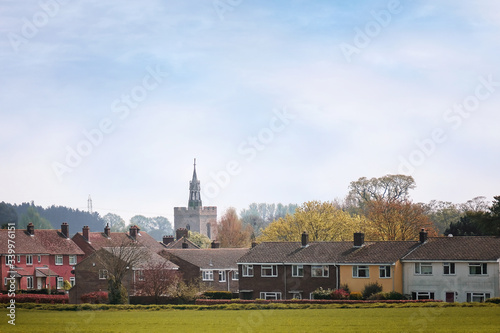 Fototapeta Naklejka Na Ścianę i Meble -  An old village church with modern housing obscuring it´s full aspect in the foreground, Boxford, Suffolk, England
