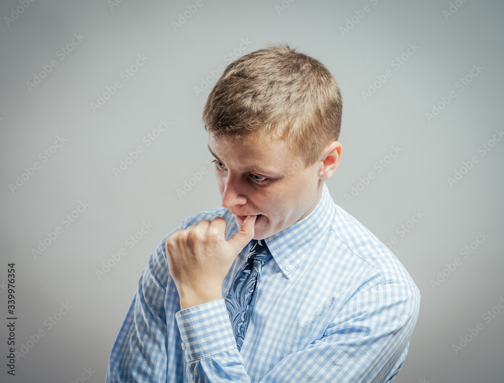 Closeup portrait of a disappointed young man with hand on cheek.