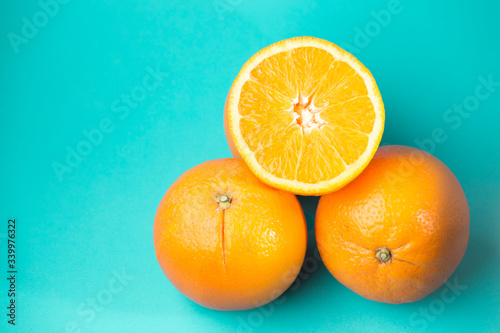 two and a half oranges placed on a blue background
