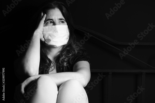 Stressed woman wearing a face mask to avoid respratory diseases photo