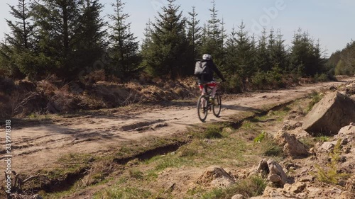 Man mountain biking on an off road dirt track in the countryside