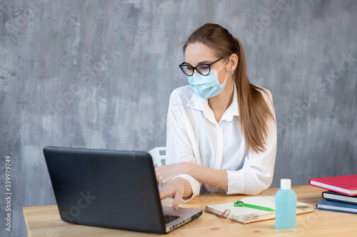 Coronavirus. Young business woman working from home wearing protective mask. Business woman in quarantine