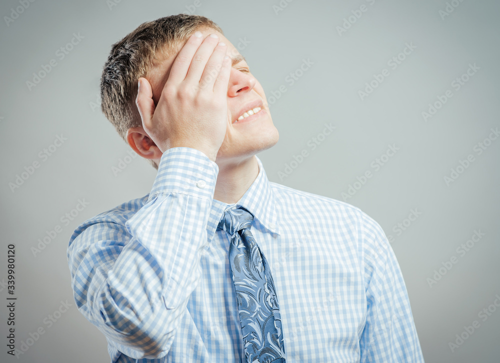 Closeup portrait of a upset young man with hand on his head Closeup portrait of a upset young man with hand on his head