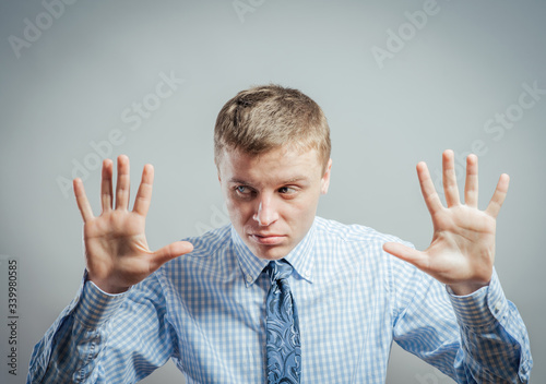Afraid man in defense attitude gesturing stop with hands